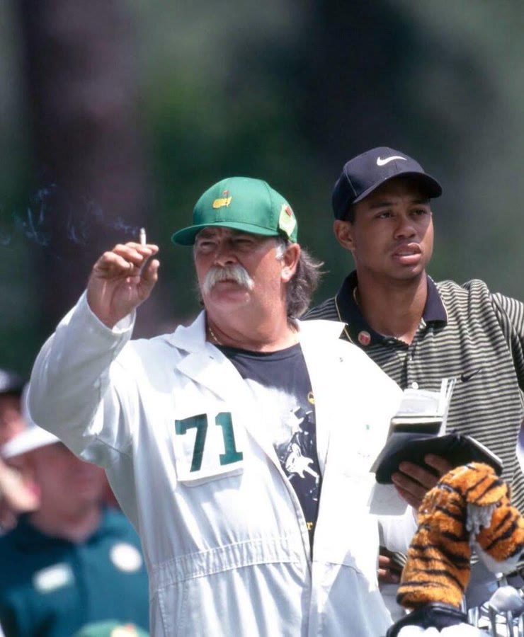 Tiger Woods’ caddie, Mike “Fluff” Cowan, checking the wind with his cigarette during the 1997 Masters